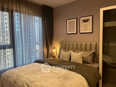Luxurious bedroom with modern decor and large windows offering city views.