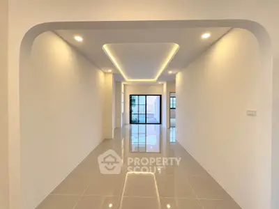 Spacious modern living room with sleek lighting and glossy tiled floors, perfect for contemporary living.