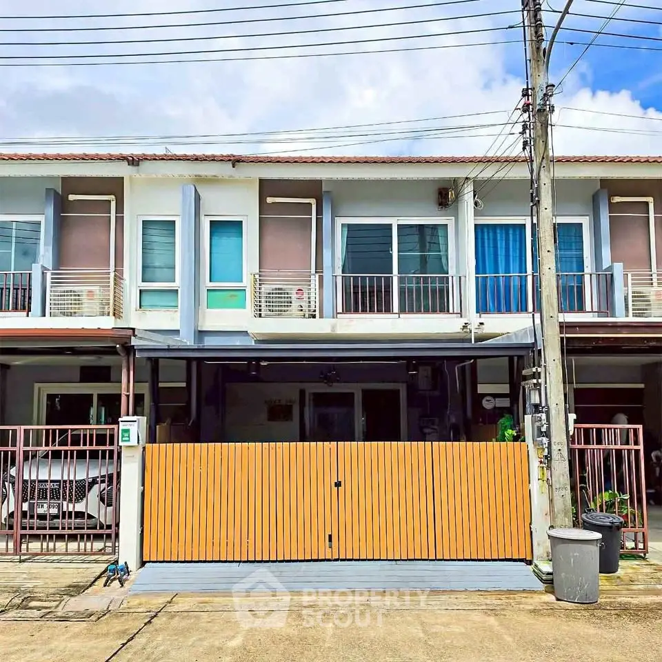 Modern townhouse exterior with gated entrance and parking space