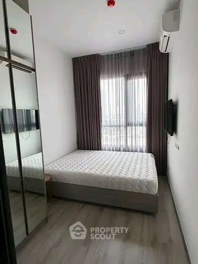 Modern bedroom with sleek design, featuring a large window, mirrored wardrobe, and wall-mounted TV.