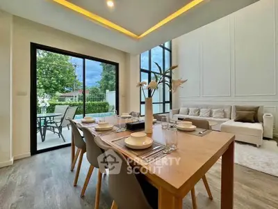Elegant dining area with modern decor and large windows offering garden view