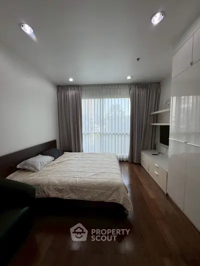 Cozy bedroom with modern furnishings and large window for natural light