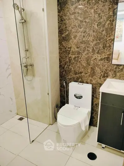Modern bathroom with elegant marble tiles and glass shower enclosure