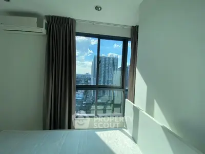 Bright bedroom with large window offering stunning city view in modern apartment