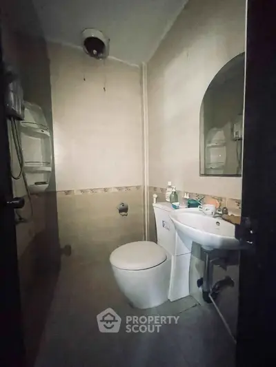 Compact bathroom with modern fixtures and neutral tiles, ideal for efficient space use.