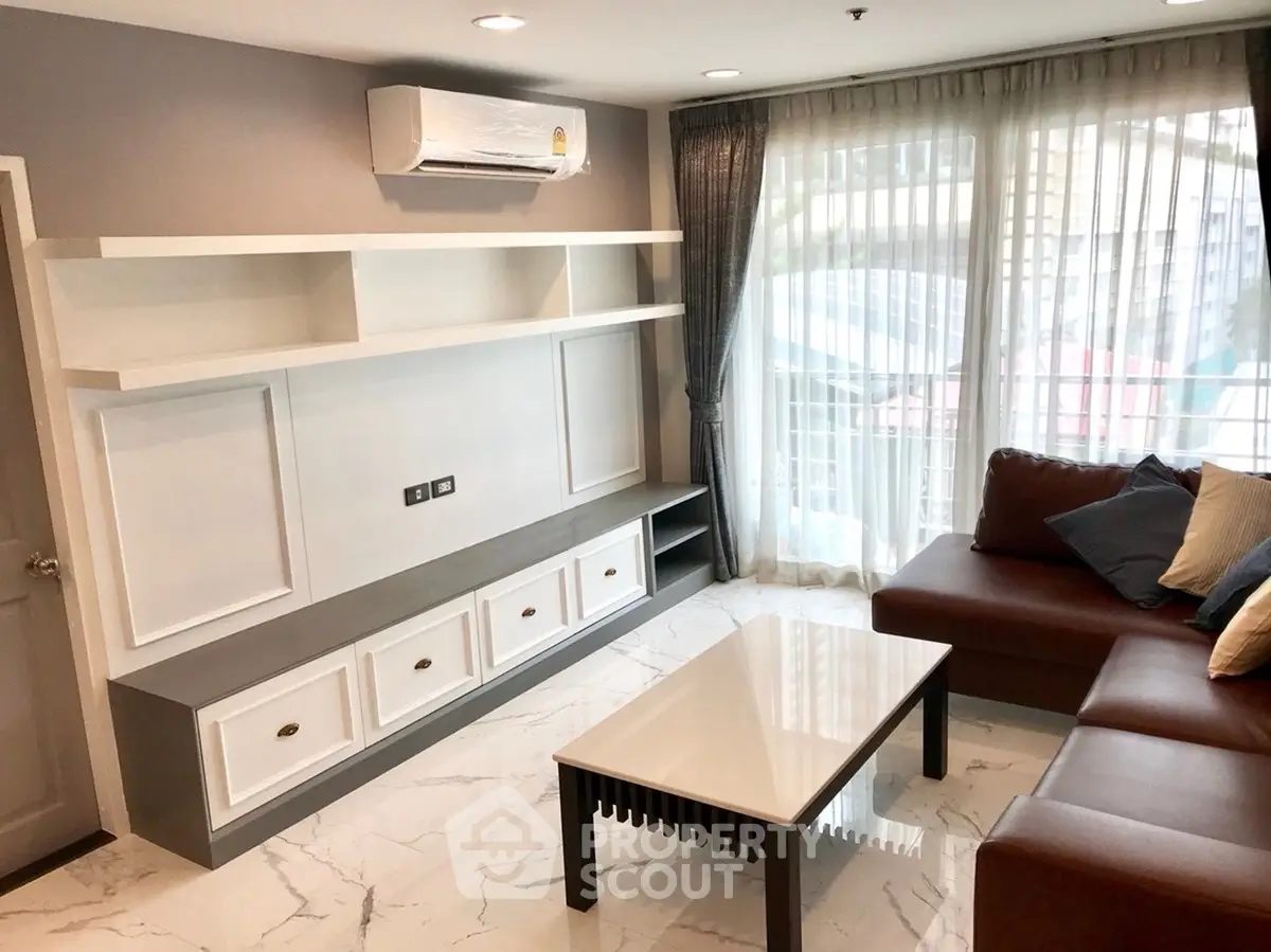 Modern living room with sleek furniture and large windows offering natural light.