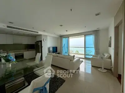 Luxurious beachfront living room with stunning ocean view and modern open kitchen layout.