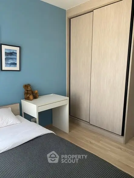 Cozy bedroom with modern wardrobe and blue accent wall