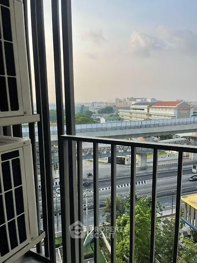 Urban balcony view with cityscape and modern rail transit system.