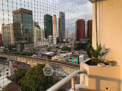 Stunning cityscape view from a high-rise balcony with lush greenery and urban skyline.