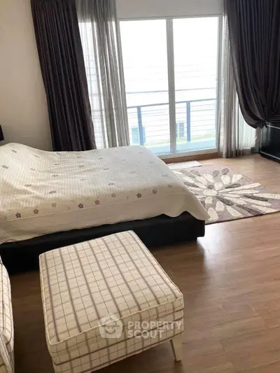 Spacious bedroom with large window and stylish decor