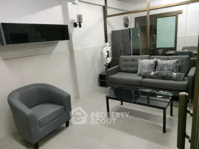 Modern living room with stylish gray furniture and glass coffee table