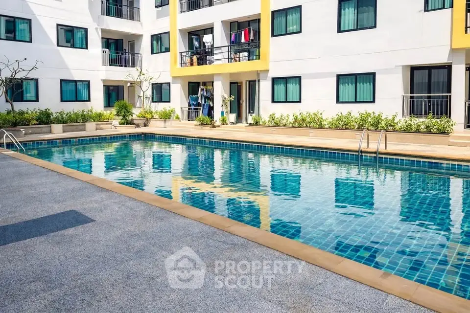 Modern apartment complex with inviting swimming pool and sunlit balconies.