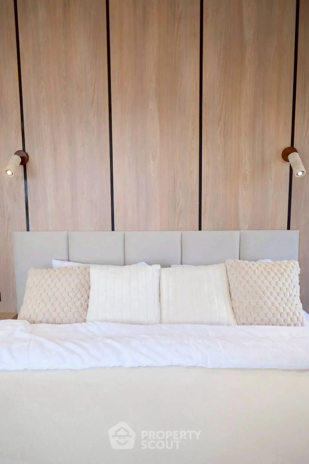 Luxurious modern bedroom with elegant wood paneling and plush bedding