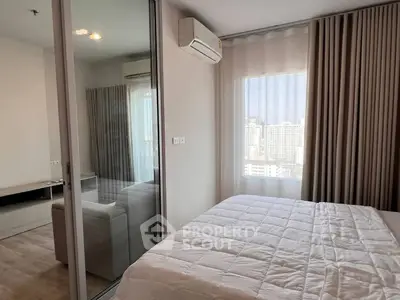Modern bedroom with city view, featuring large window and air conditioning unit.