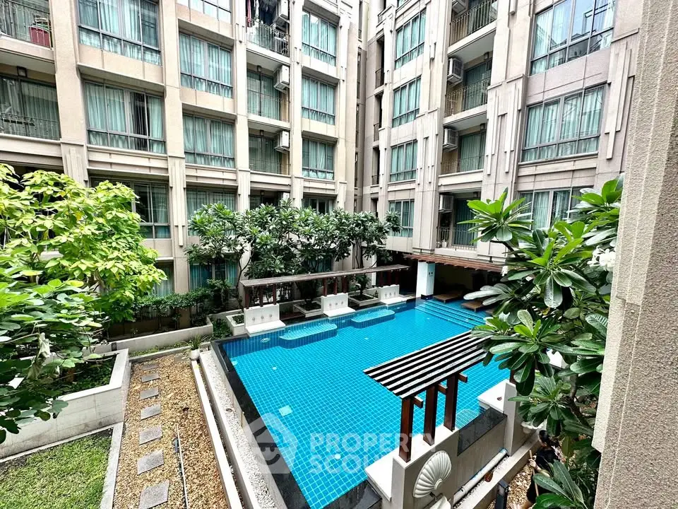 Luxurious apartment complex with a stunning outdoor pool and lush greenery.