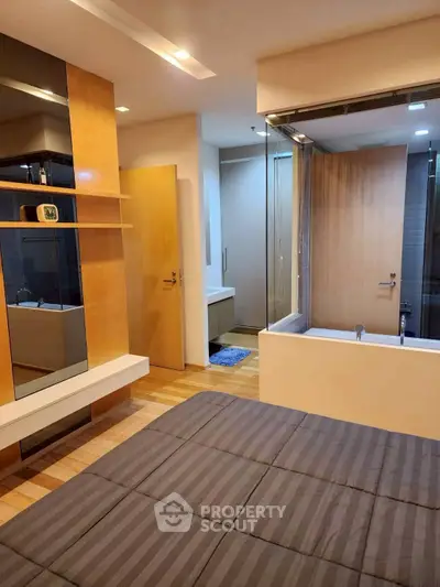 Modern bedroom with ensuite bathroom featuring sleek wooden finishes and glass partition.