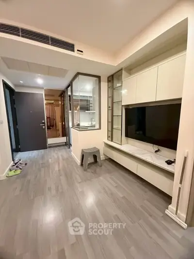 Modern living room with sleek flooring and built-in TV unit in a stylish apartment.