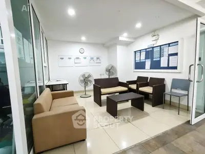 Modern office waiting area with comfortable seating and fans