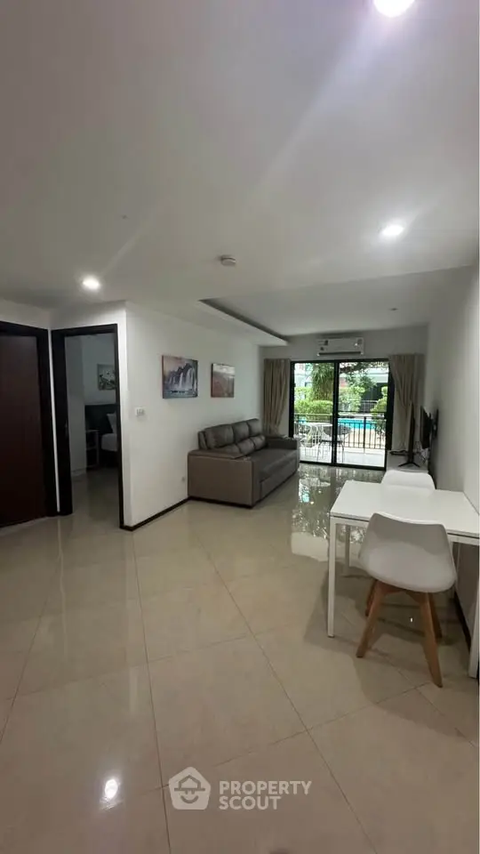 Spacious living room with modern decor and balcony view in a stylish apartment.