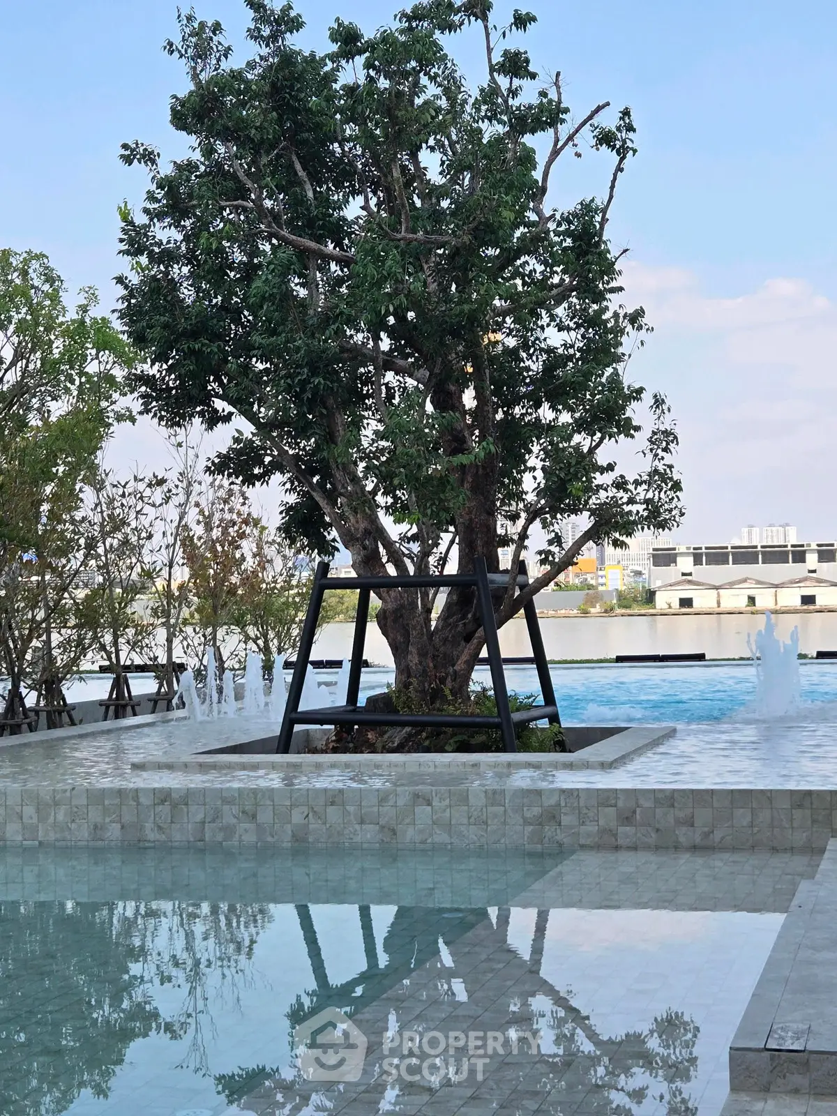 Luxurious poolside view with serene water reflections and lush greenery
