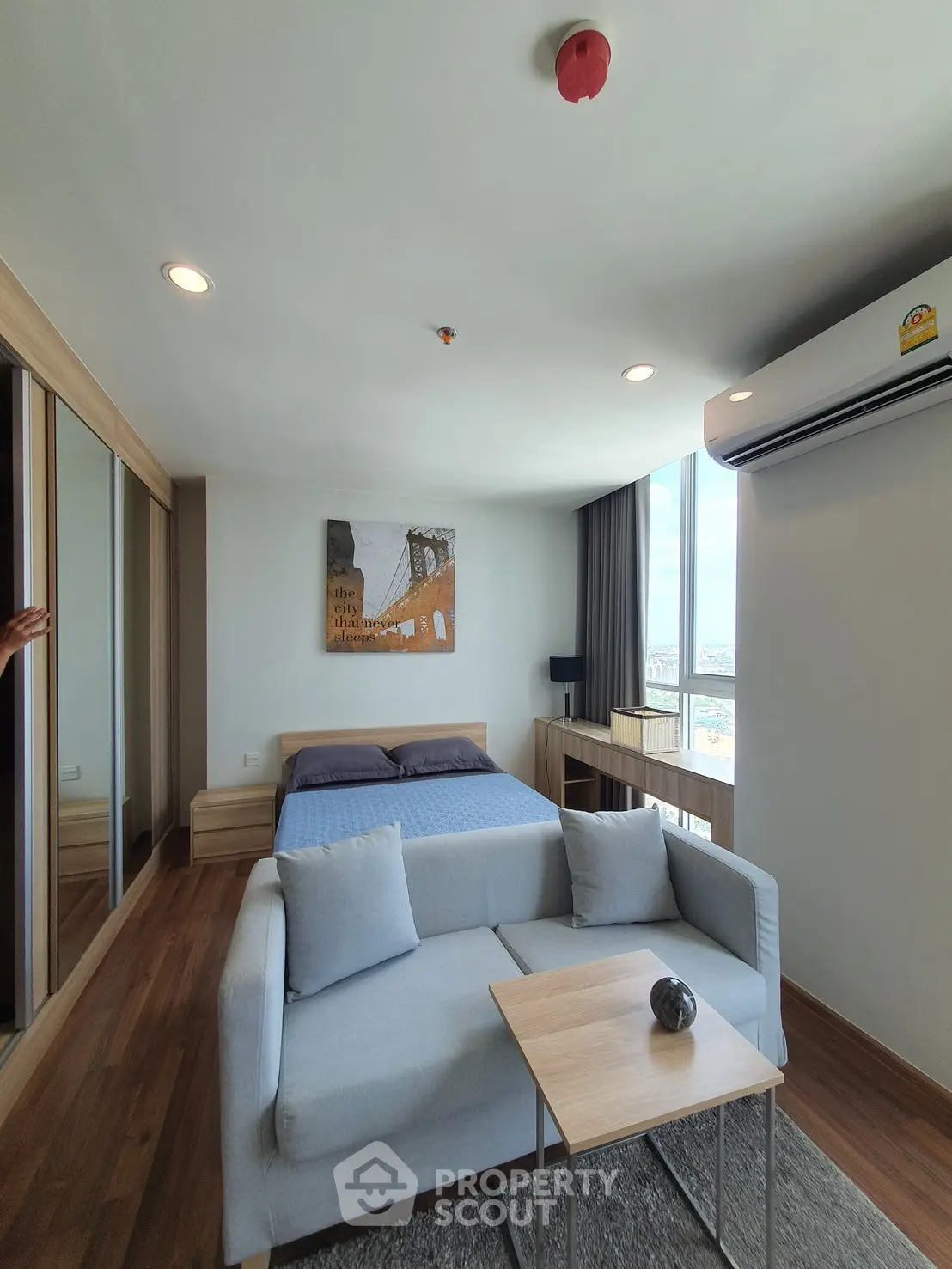 Modern bedroom with cozy sofa and large window view