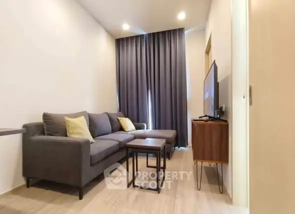 Modern living room with stylish gray sofa and sleek TV setup.