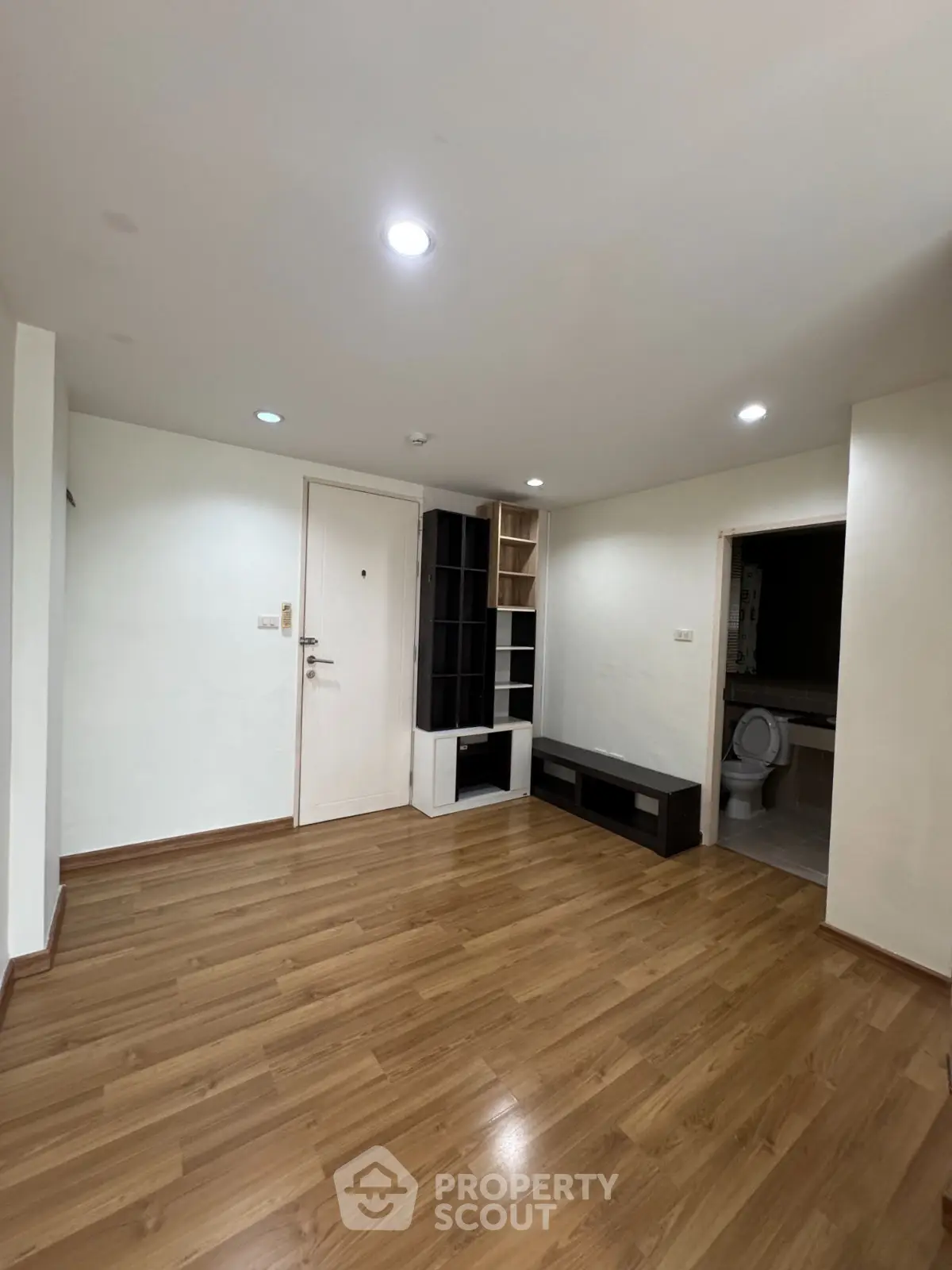 Spacious living room with wooden flooring and built-in storage, ideal for modern living.