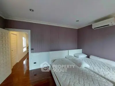 Spacious bedroom with twin beds and air conditioning in modern home.
