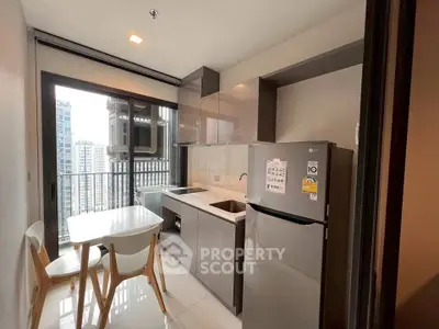Modern kitchen with sleek appliances and balcony view in urban apartment