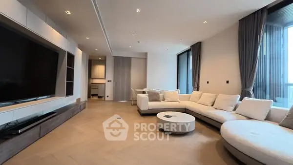 Luxurious modern living room with spacious seating and large TV, perfect for relaxation.
