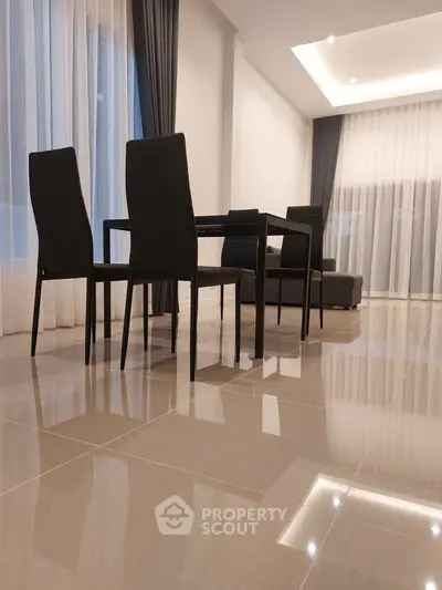 Modern dining area with sleek black chairs and glossy tiled flooring
