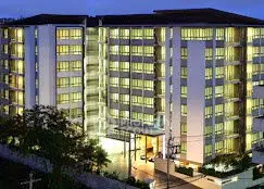 Modern multi-story residential building with illuminated windows at dusk.