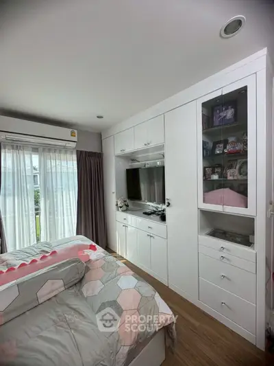Cozy bedroom with built-in wardrobe and large window for natural light