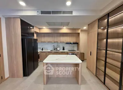 Modern kitchen with island, sleek cabinetry, and built-in appliances in luxury home.