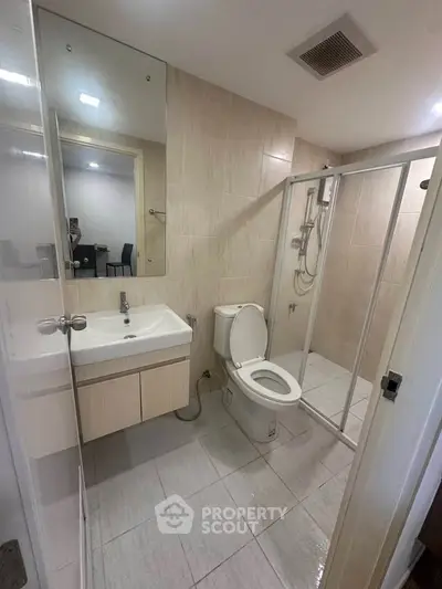 Modern bathroom with glass shower enclosure and sleek fixtures
