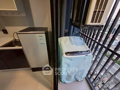 Compact balcony with washing machine and city view, ideal for urban living.