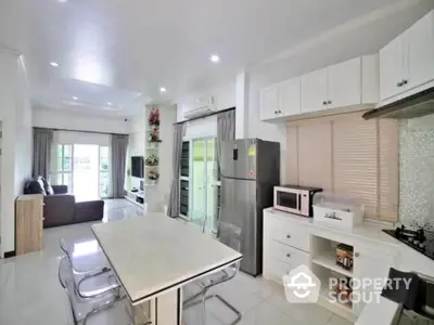 Modern open-layout kitchen and living room with sleek appliances and bright decor