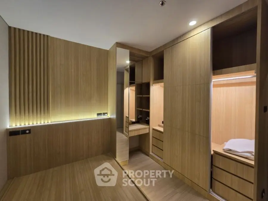 Luxurious modern walk-in closet with wooden finishes and ambient lighting