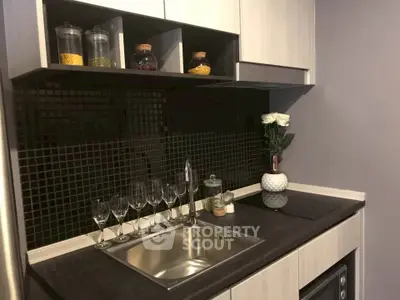 Modern kitchen with sleek black backsplash and elegant glassware display