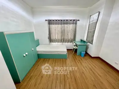 Spacious bedroom with modern furniture and wooden flooring, perfect for comfortable living.