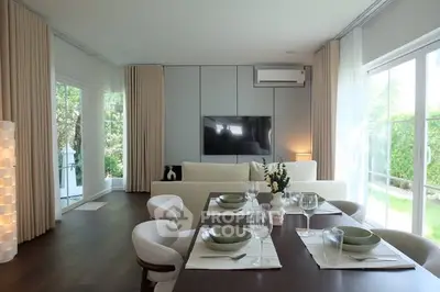 Modern living room with elegant dining area and large windows overlooking a lush garden.