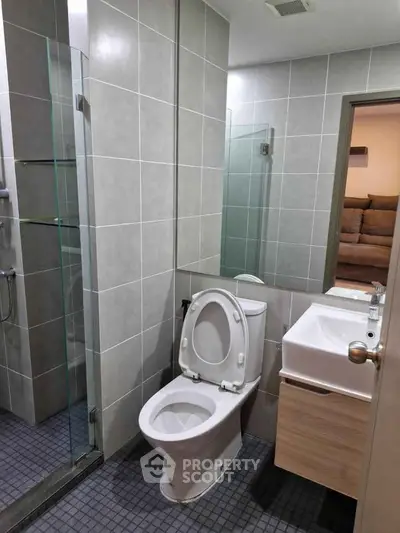 Modern bathroom with sleek design and glass shower enclosure in a contemporary apartment.