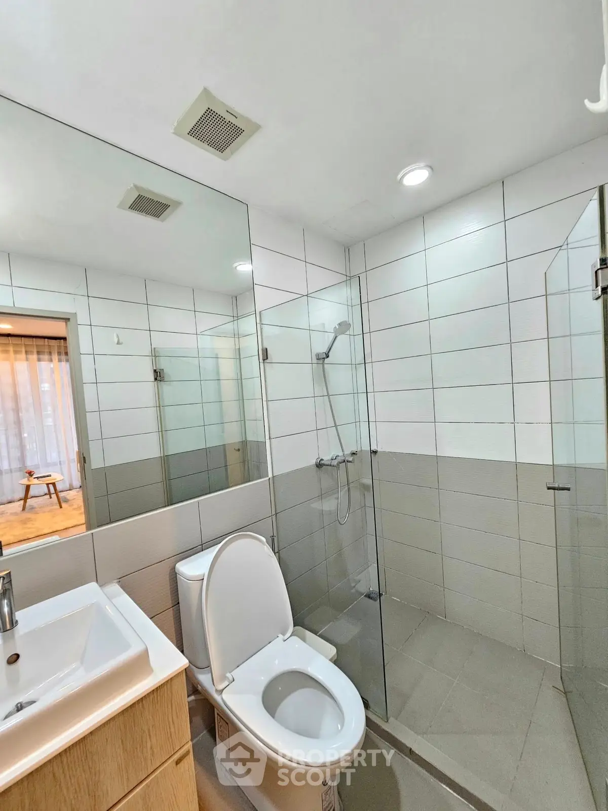 Modern bathroom with glass shower and sleek fixtures in contemporary home.