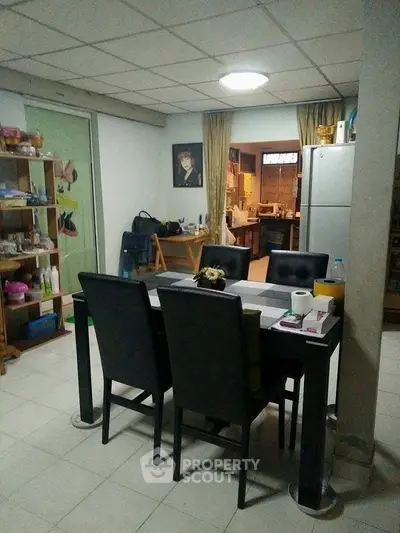 Cozy dining area with modern furniture and adjacent kitchen in a welcoming home setting.