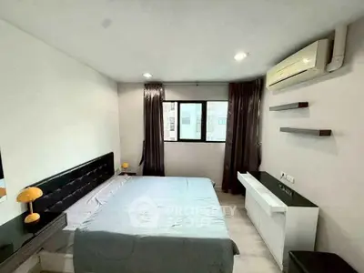 Modern bedroom with sleek design, featuring a large bed, air conditioning, and ample natural light.