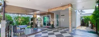 Spacious covered patio with checkered flooring and outdoor dining area.