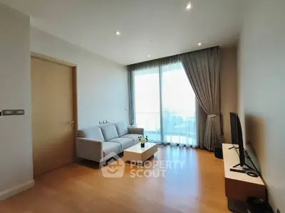 Modern living room with sleek furniture and large window offering natural light