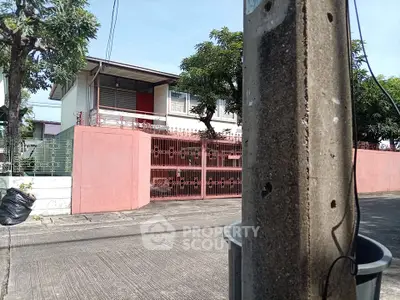 Charming suburban home with gated entrance and lush greenery, perfect for family living.