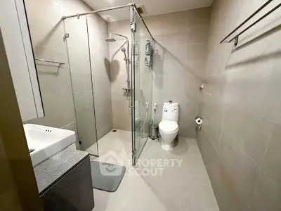 Modern bathroom with glass shower enclosure and sleek fixtures